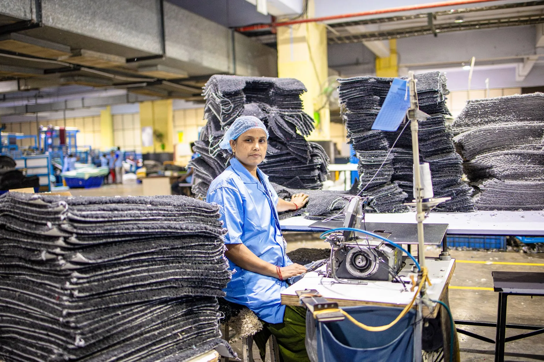 Hands weaving ramie fabric, soft light, muted colors, sustainable garment making.