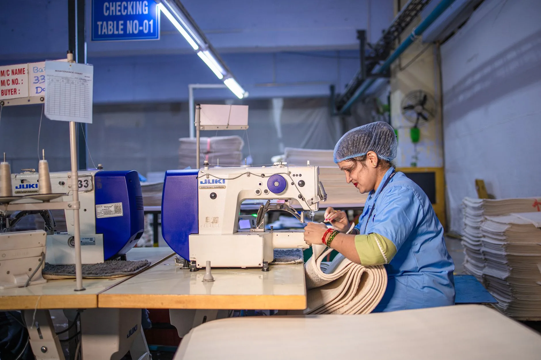 Modern fashion supply chain, workers sewing garments in a well-lit, organized factory, sustainability in fashion.